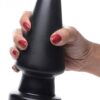 A hand with red nails holding a black silicone toy