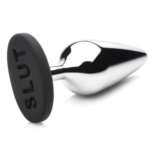 Metal anal plug with a black silicone base saying 'SLUT'