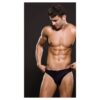 Muscular man in black underwear, posing against a dark background