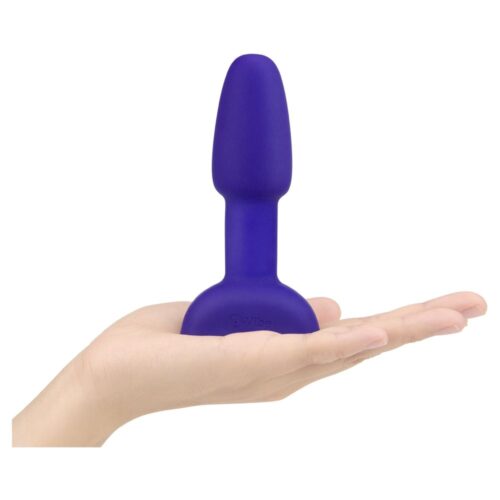 A purple silicone anal plug held in a hand