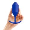 A hand holding a blue silicone pleasure device