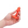 A hand holding a bright orange silicone toy