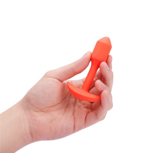 A hand holding a bright orange silicone toy