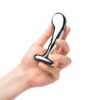 A hand holding a shiny stainless steel P-spot training device
