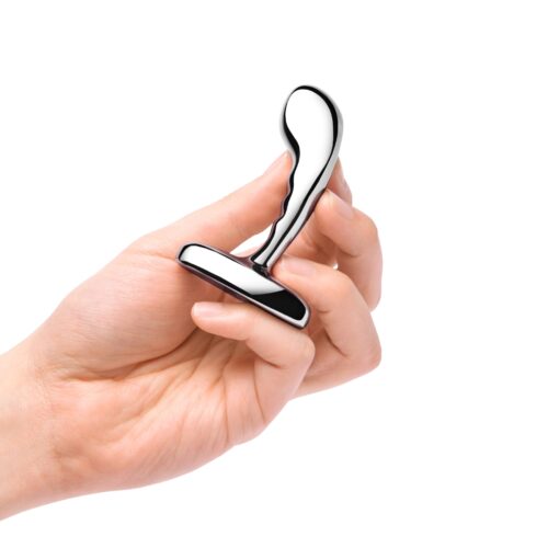 A hand holding a shiny stainless steel P-spot training tool