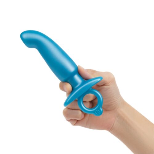 A hand holding a blue silicone toy with a tapered end