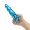 A hand holding a blue anal toy with a flared base