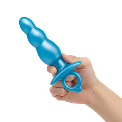 A hand holding a blue anal toy with a flared base