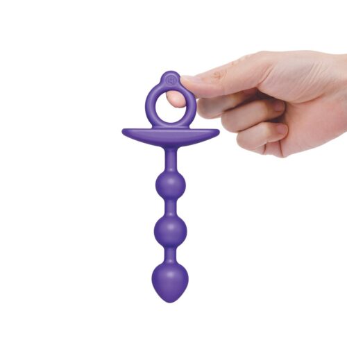 Purple silicone anal plug, held by a hand with a looped handle