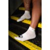 Feet in white socks with paw prints on black and yellow stairs