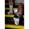 Feet wearing socks with 'DISCREET' and 'PROLIFIC' on stairs