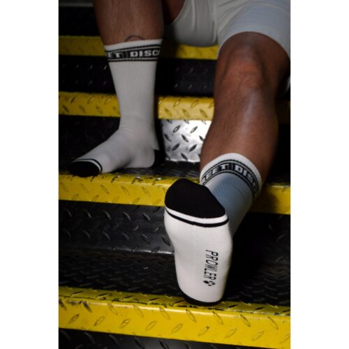 Feet wearing socks with 'DISCREET' and 'PROLIFIC' on stairs