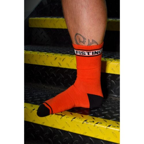 Orange socks with 'FISTING' band, worn on a foot on yellow steps