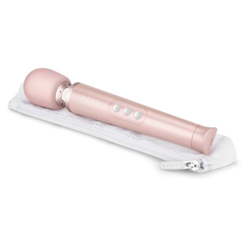 Le Wand Petite Wand Vibrator in gold, lying on a white storage pouch