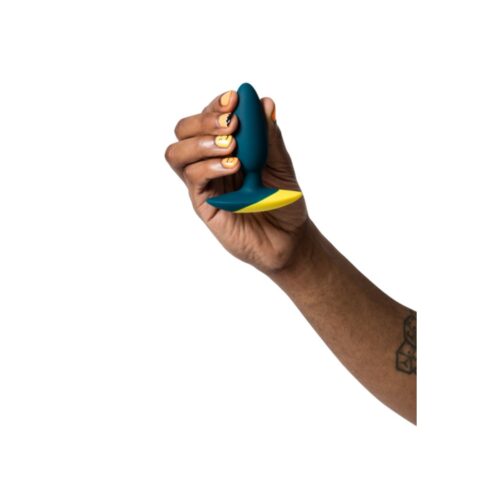 A hand with nail art holds a blue and yellow toy