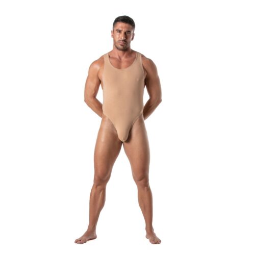Muscular man in a beige bodysuit standing confidently