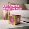 Experience the fun of pimple popping without the mess with the Bubblegum Stuff Pop Zit! Colorful 'Pop Zit' toy box on a table, with a pink popping toy visible inside