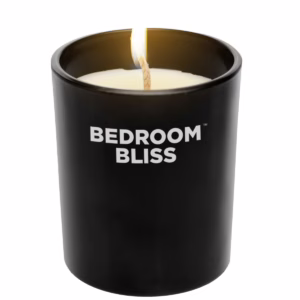 Ignite romance with the soothing scent of our Vanilla massage candle. Bedroom Bliss Lover's Massage Candle Vanilla with a lit wick, available at The Loving Company.
