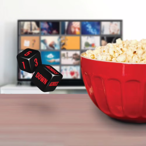 Let the dice decide your next movie night with Bubblegum Stuff's Dice-Flix! Black dice with red text are floating above a red bowl of popcorn