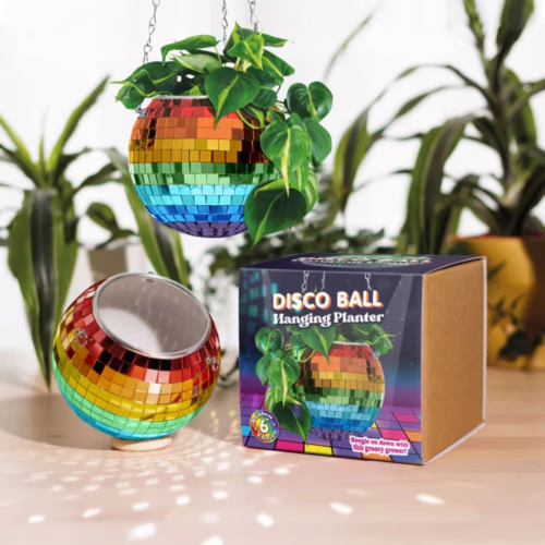 Add a pop of color to your home with this playful disco ball hanging planter! Disco ball hanging planter in rainbow colors, with plant and packaging on display