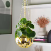 Brighten your space with this playful gold disco ball hanging planter. Gold disco ball hanging planter with green leaves