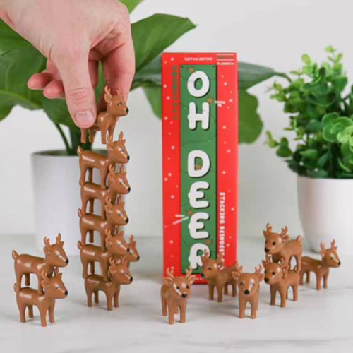 Challenge your friends with the fun and festive 'Oh Deer' game! A hand stacking reindeer figures next to the 'Oh Deer' game box