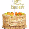 A birthday cake with a gold 'Happy Fucking Birthday' topper, topped with carrot decorations
