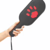 A hand holding the Prowler Red Puppy Paddle with a black surface and a red paw print