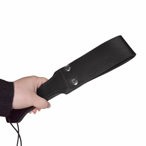 Black leather paddle held in a hand