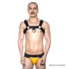 Man wearing a black Prowler Red Noir Harness, with yellow jockstrap