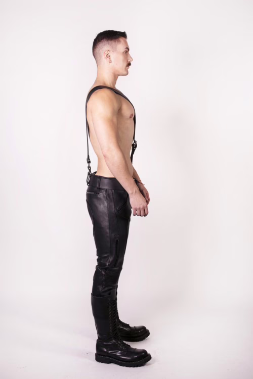 Model in black leather pants and combat boots, wearing a black belt
