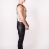 Model in black leather pants and boots, showcasing a harness