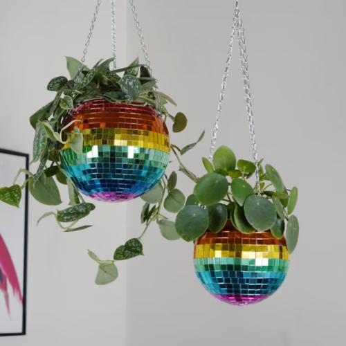 Add a touch of sparkle to your space with these vibrant disco ball hanging planters. Two rainbow-colored disco ball hanging planters with plants