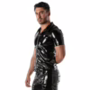 A man wearing a black vinyl zipped vest, poses against a white background
